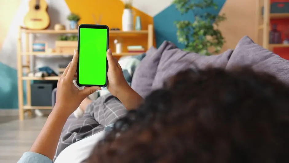 Remaja di Pulausemakau pegang smartphone sambil duduk di teras rumah